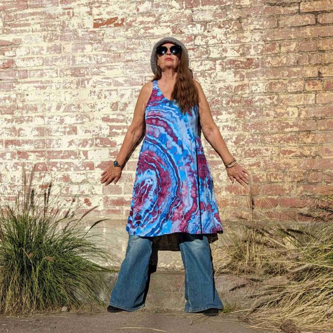 a woman standing in front of a brick wall.
