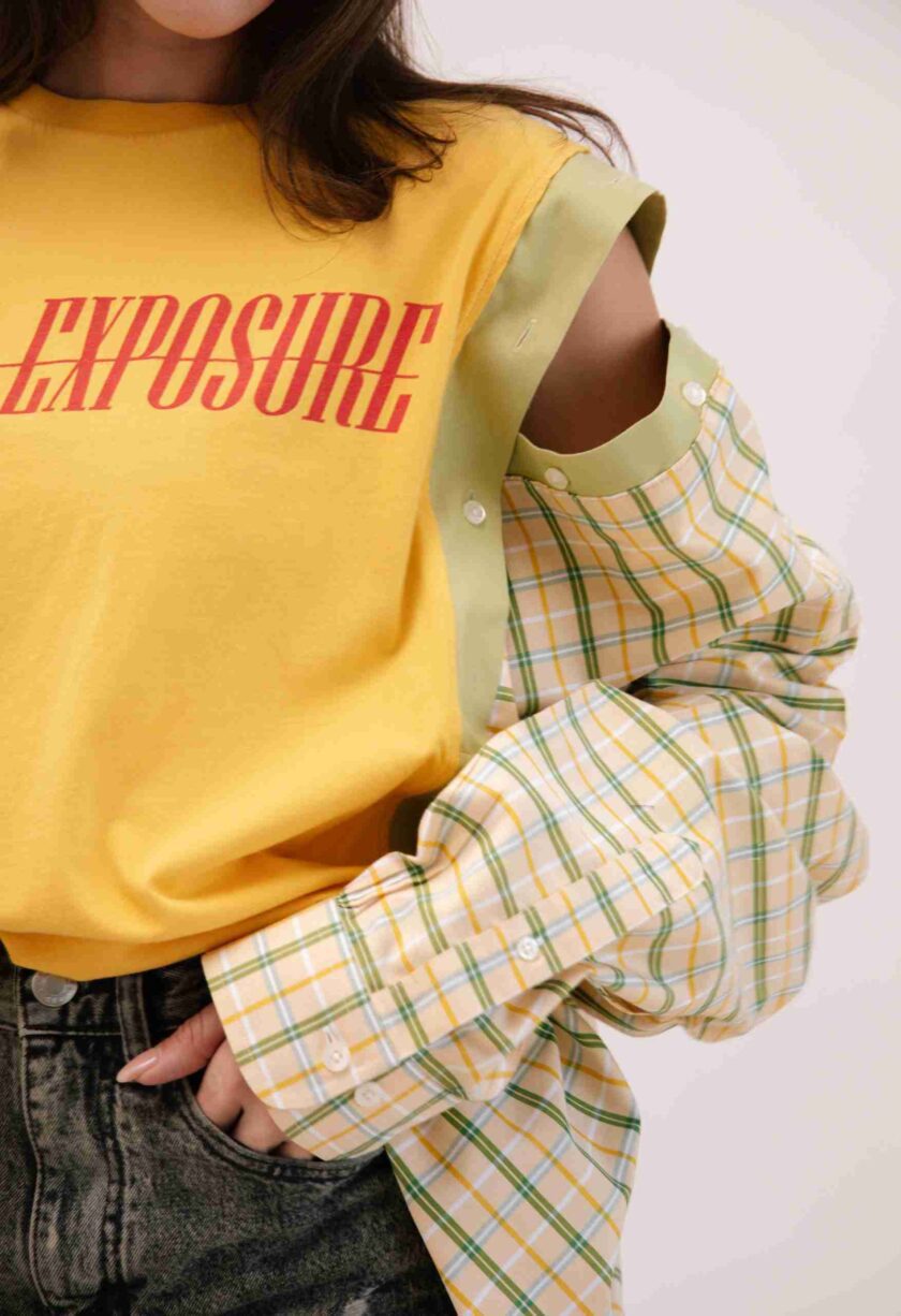 a woman wearing a yellow shirt with the word exposure on it.