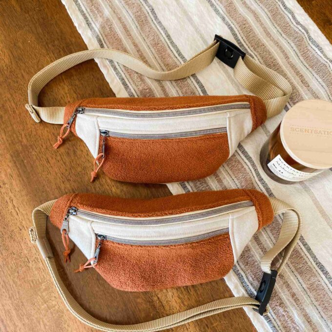 two brown and white bags sitting on top of a wooden floor.