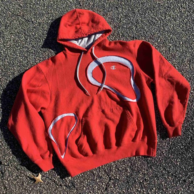 a red hoodie laying on the ground.