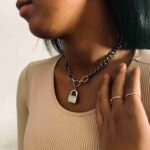 a woman wearing a necklace with a lock on it.