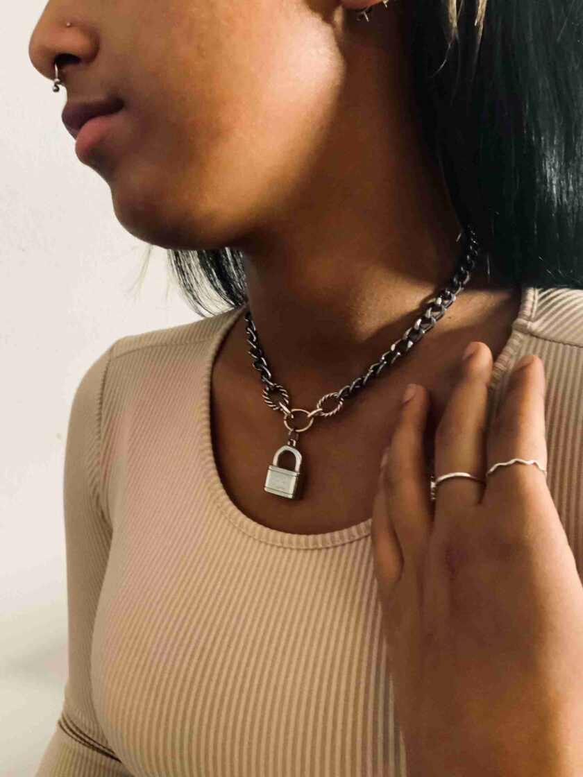 a woman wearing a necklace with a lock on it.