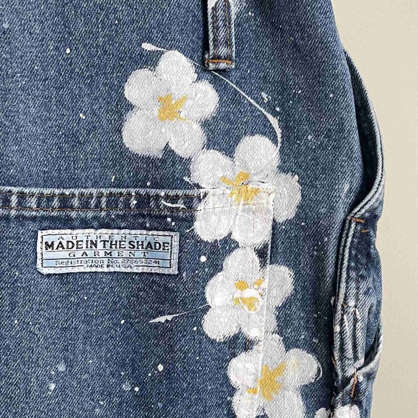 a close up of a jean jacket with flowers on it.