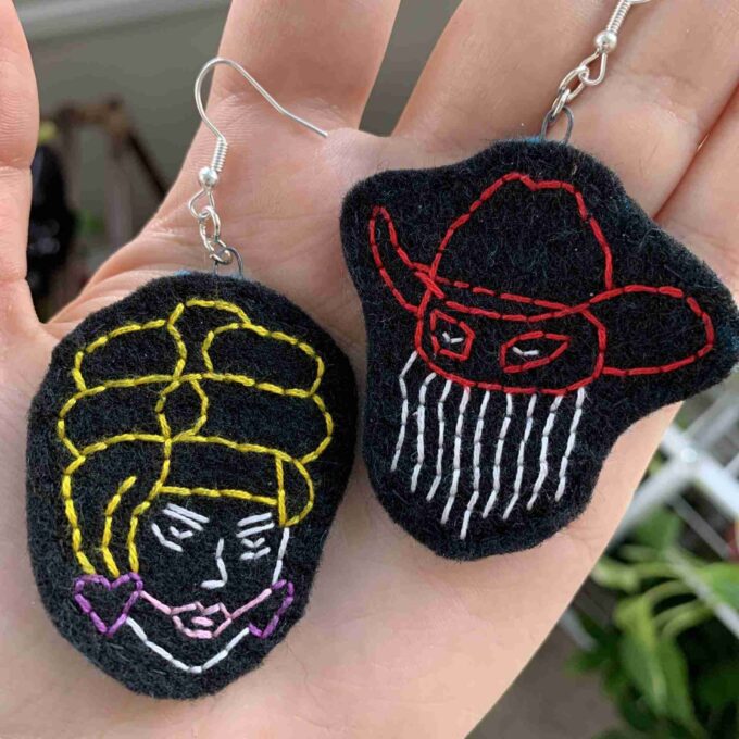 a pair of handmade earrings with a picture of a woman and a man.