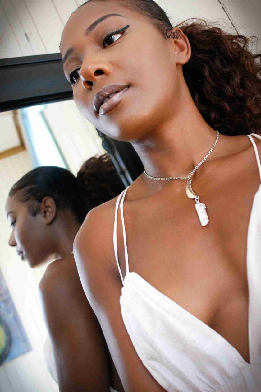 a woman wearing a white dress and a necklace.
