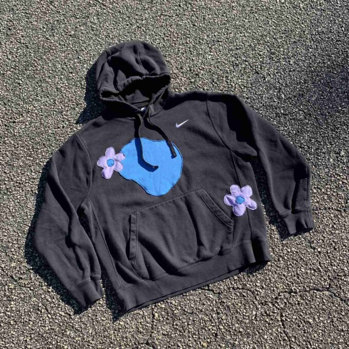 a black hoodie with a blue face on it.