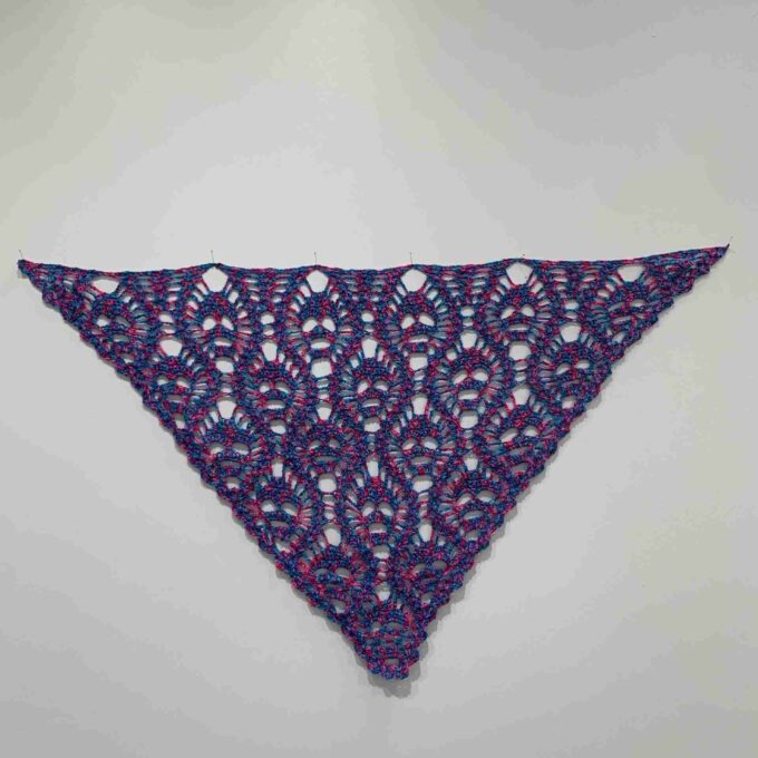 a purple and blue triangle shaped object on a white wall.