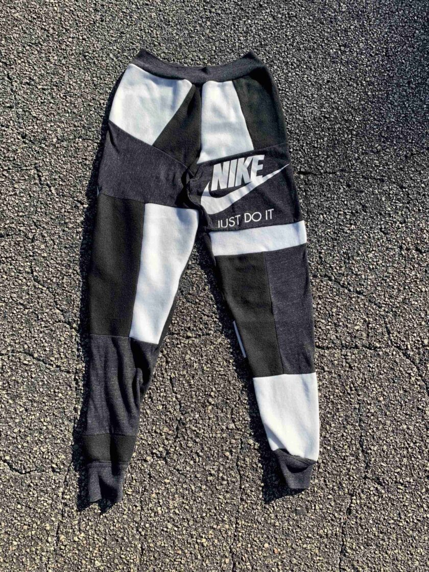 a pair of black and white nike sweatpants laying on the ground.