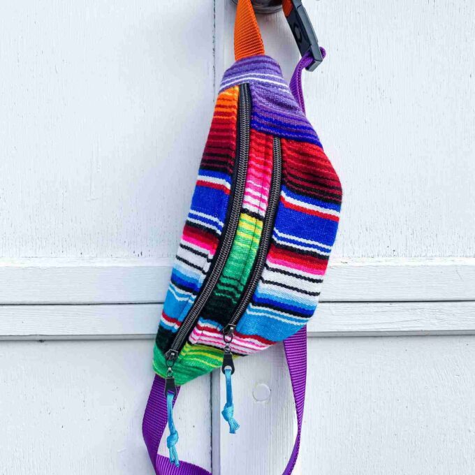 a colorful backpack hanging on a white door.