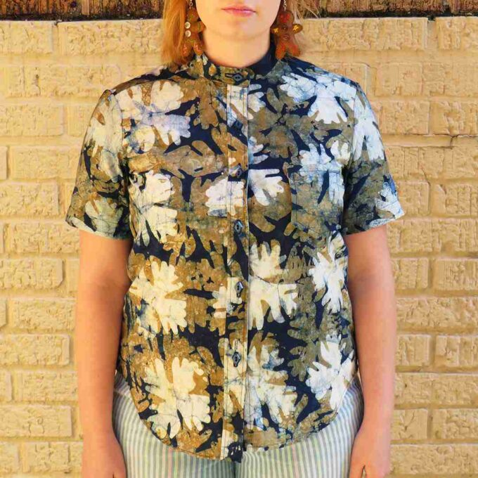 a woman standing in front of a brick wall.
