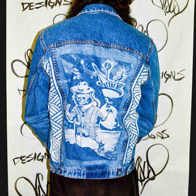 a person wearing a jean jacket with a drawing on it.