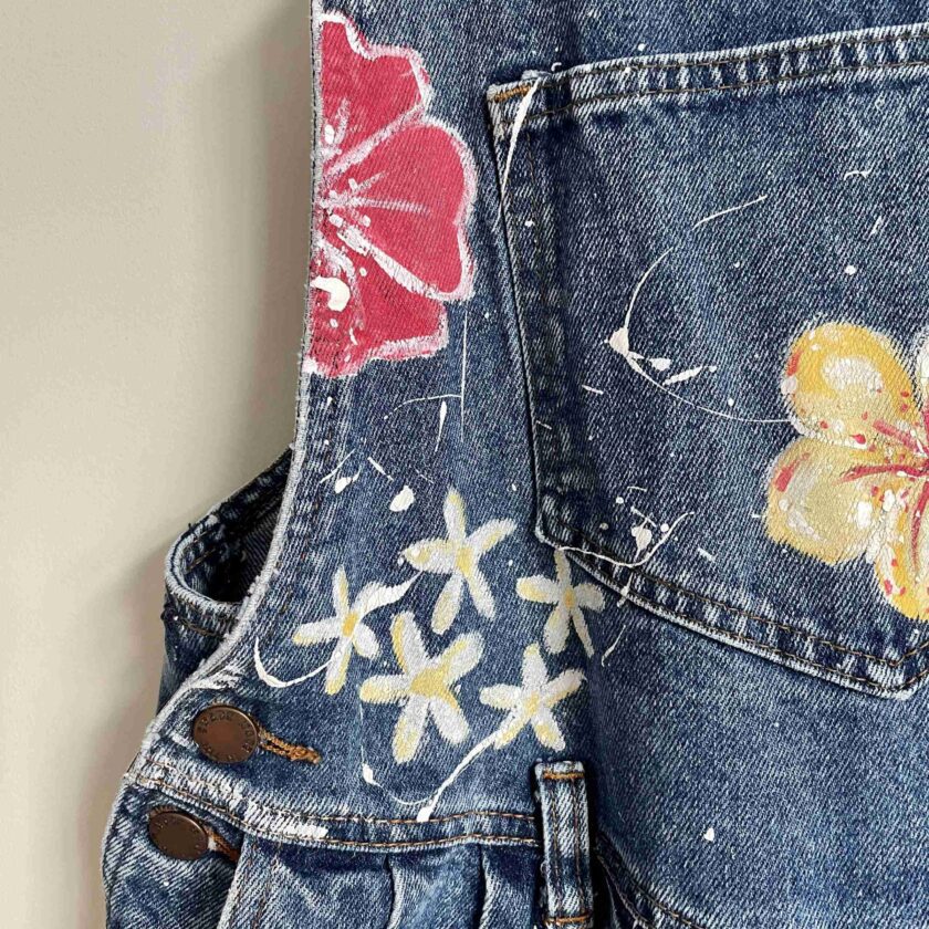 a pair of jeans with flowers painted on them.