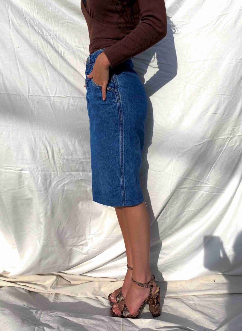 a woman in a brown shirt and blue skirt.