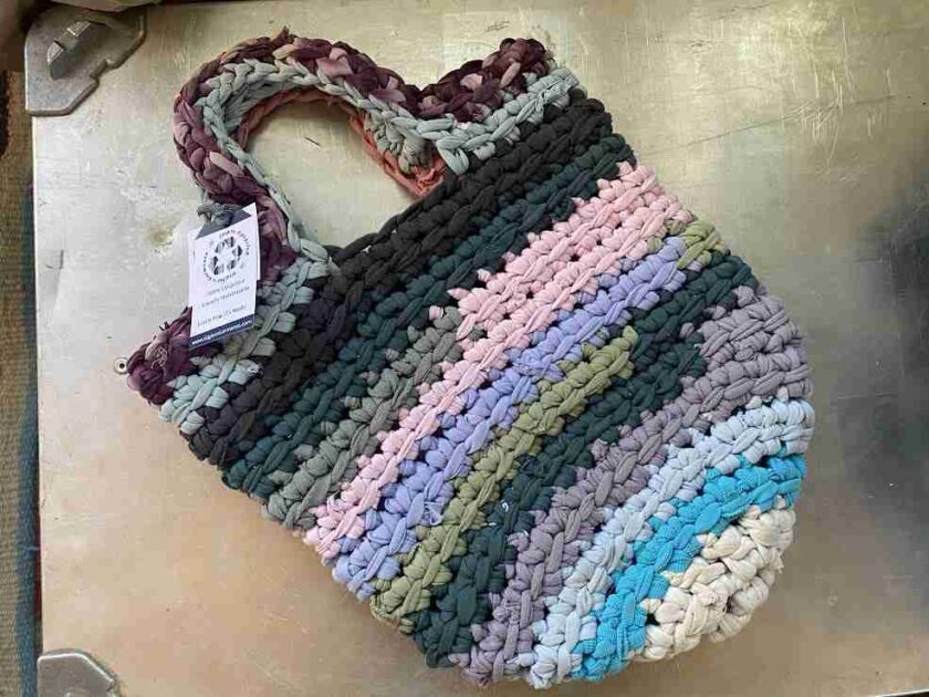 a multicolored crocheted bag sitting on top of a table.