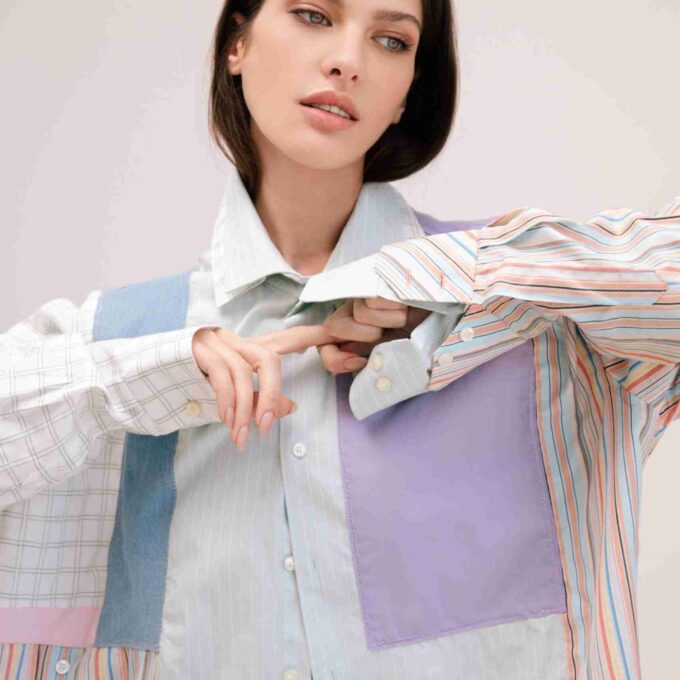 a woman wearing a multicolored shirt and tie.