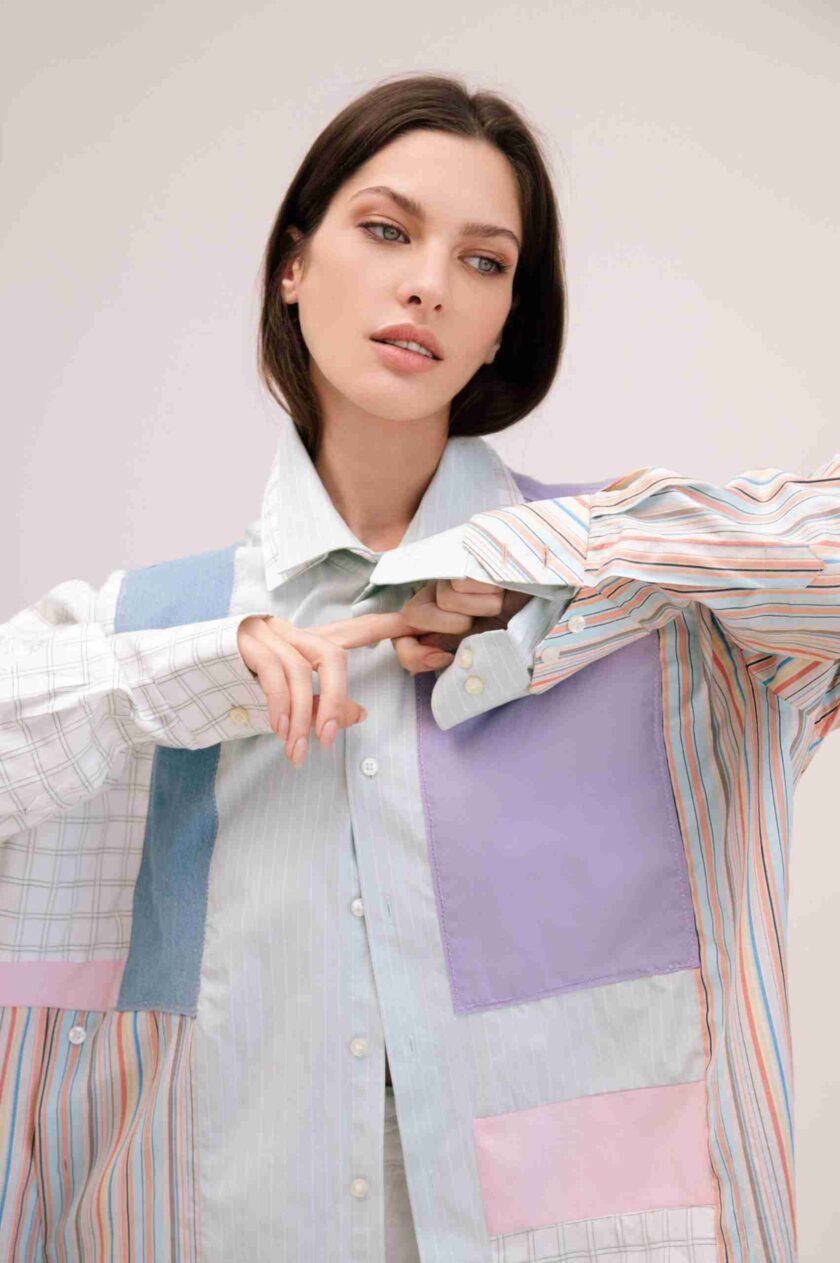 a woman wearing a multicolored shirt and tie.
