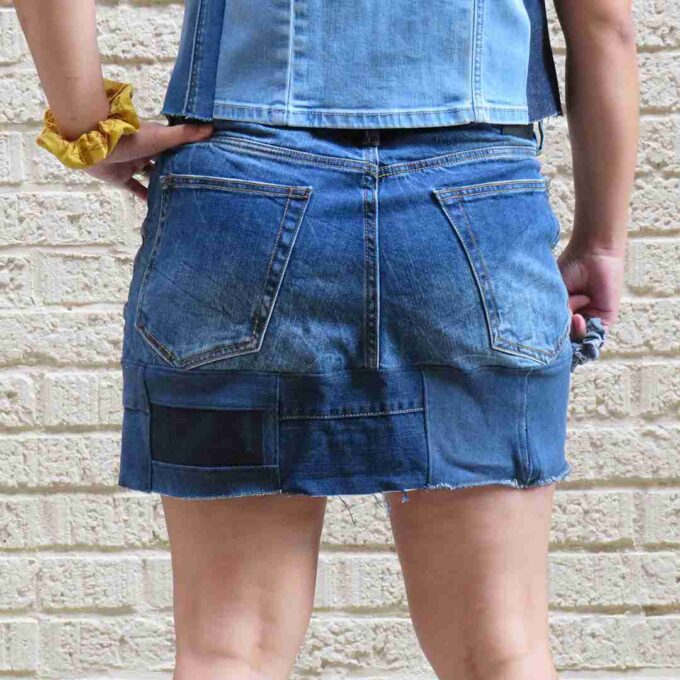 a person wearing a jean skirt and yellow shoes.