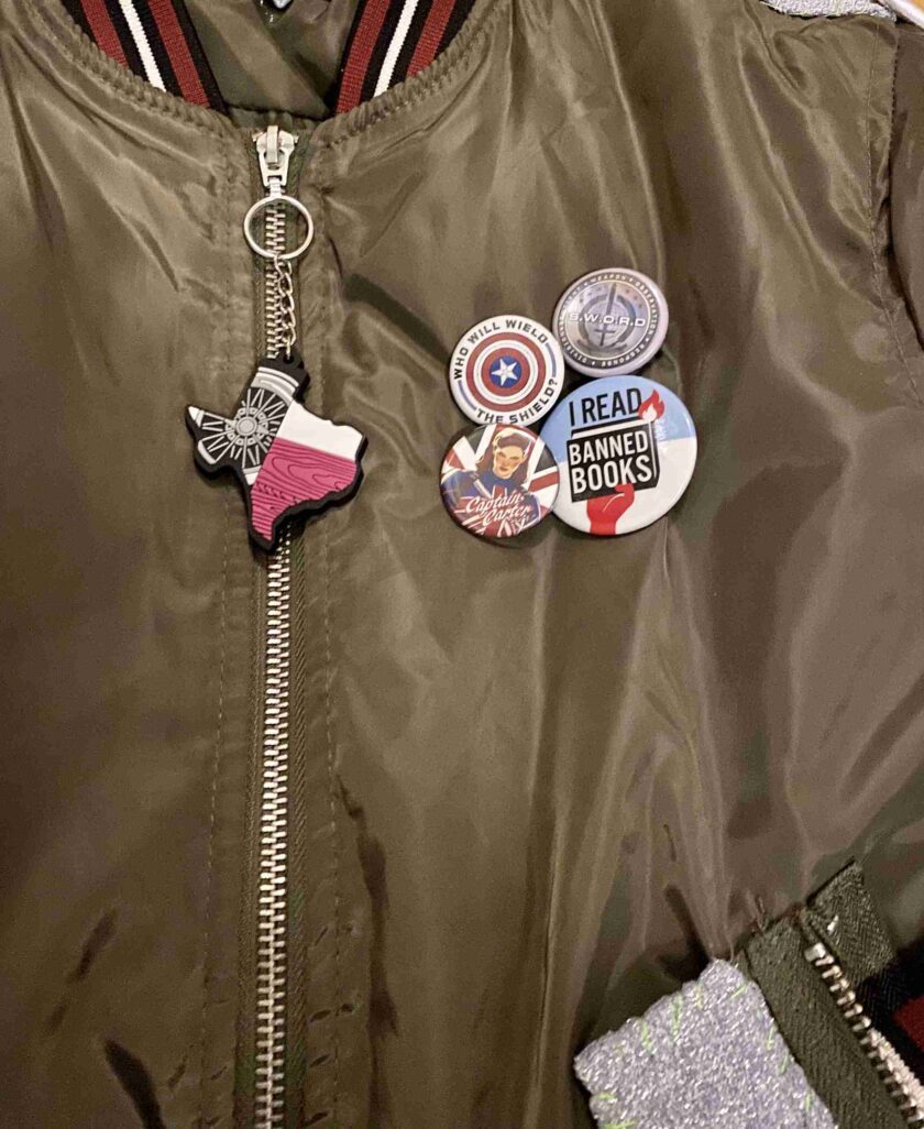 a bomber jacket with badges attached to it.