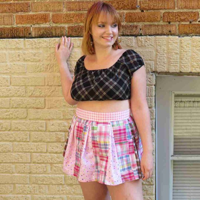 a woman standing in front of a brick wall.