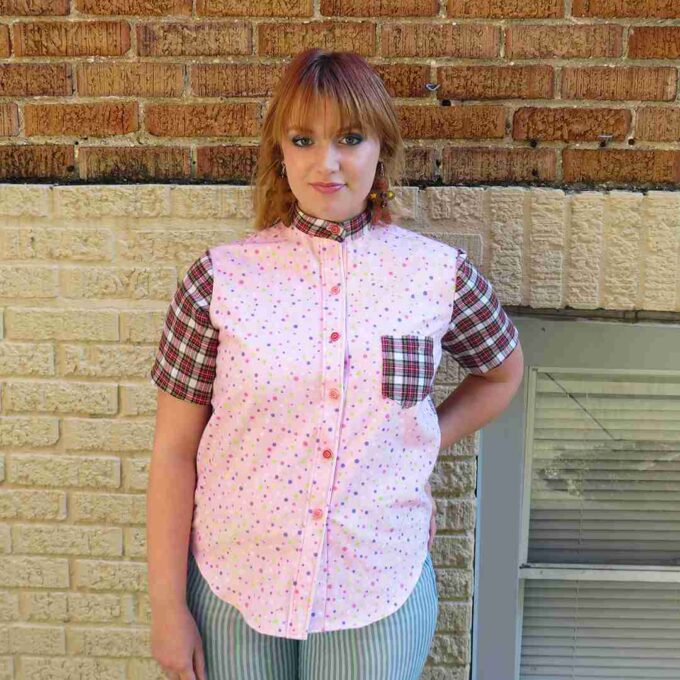 a woman standing in front of a brick wall.