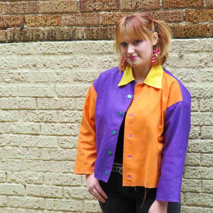 a woman standing in front of a brick wall.