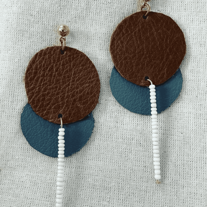 a pair of brown and blue leather earrings.