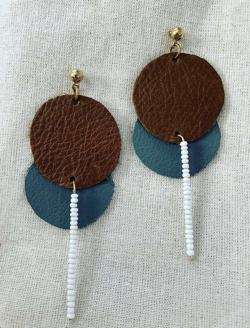 a pair of brown and blue leather earrings.