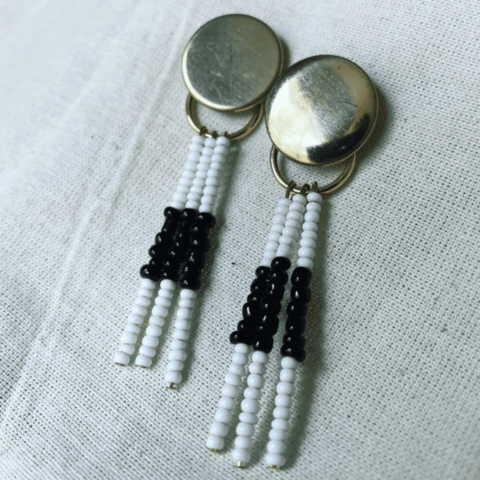 a pair of white and black beaded earrings.