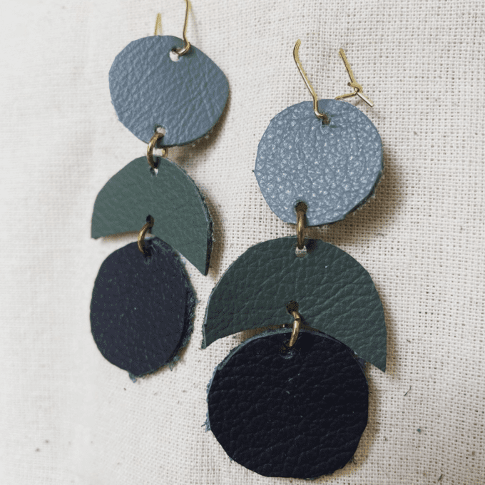 a pair of blue and green leather earrings.