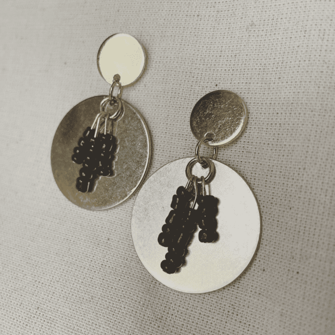 a pair of earrings with black beads hanging from them.