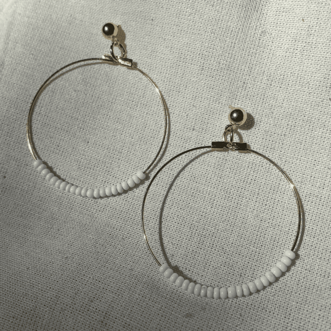 a pair of hoops with beads hanging from them.