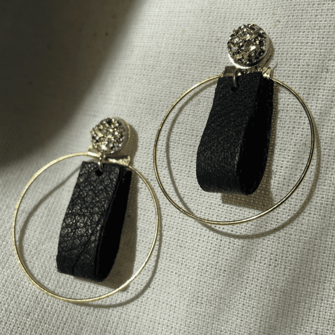 a pair of black and gold hoop earrings.