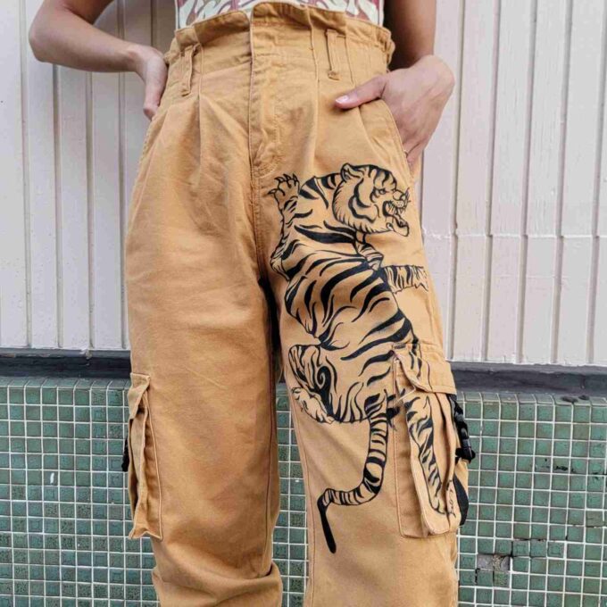a woman wearing tiger print pants and a tank top.