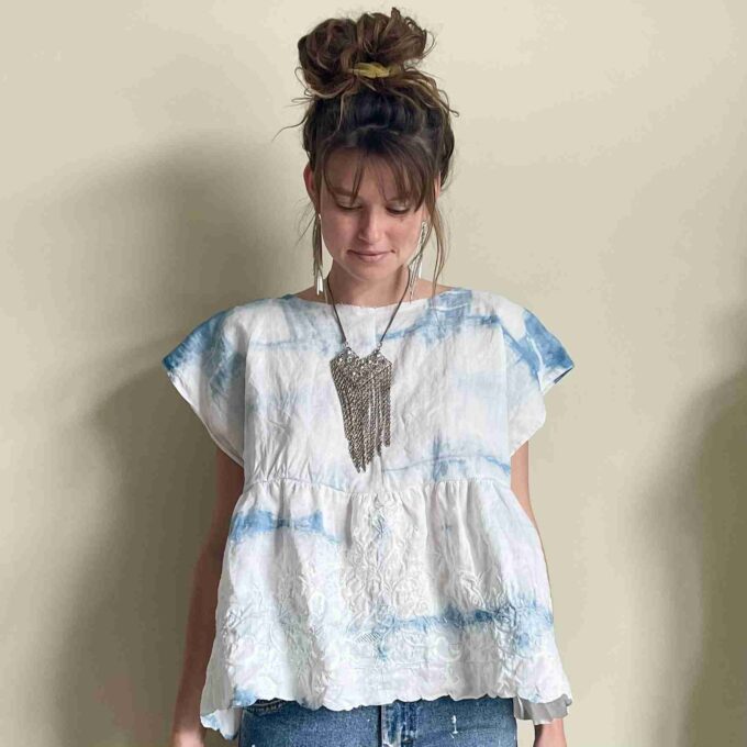 a woman standing in front of a white wall.