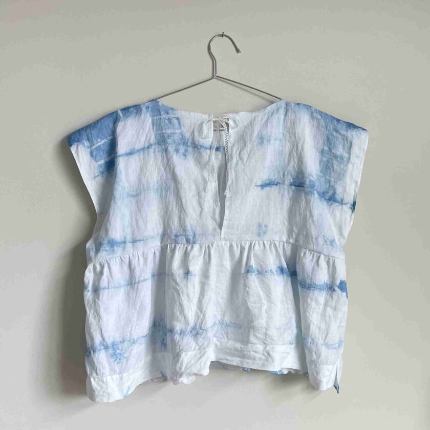 a white and blue shirt hanging on a hanger.