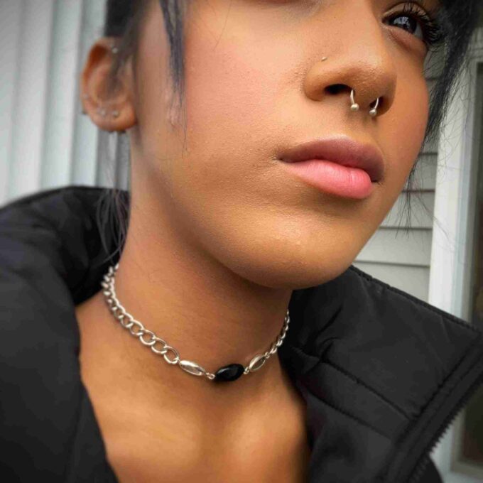 a close up of a person wearing a choker.