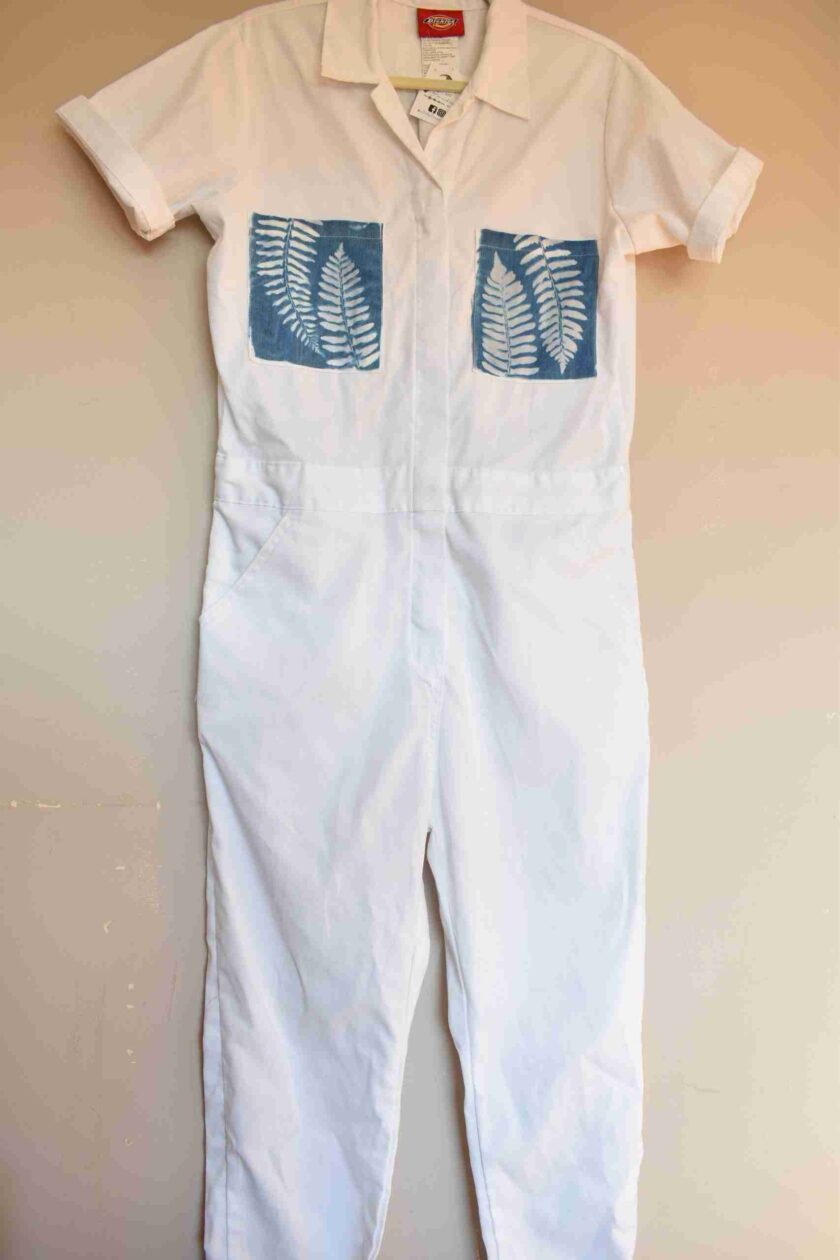 a white jumpsuit with blue palm leaves on it.