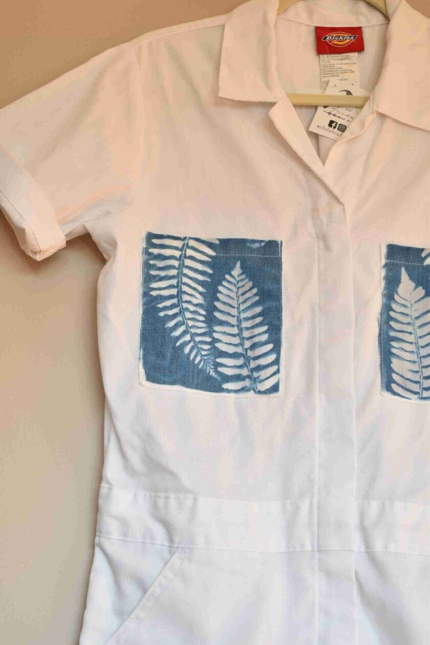 a white shirt with blue leaves on it.