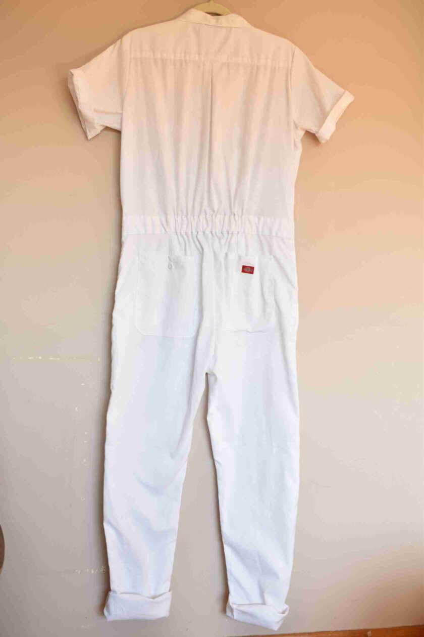 a white jumpsuit hanging on a wall.