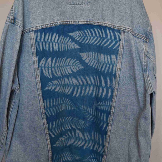 a denim jacket with a blue design on it.