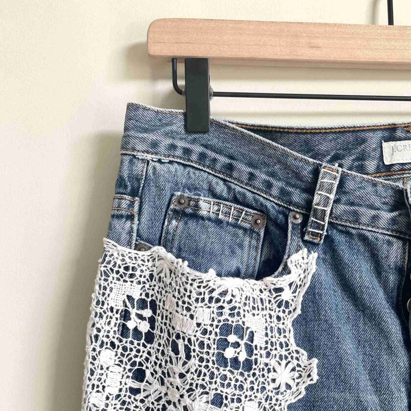 a pair of jeans hanging on a clothes rack.