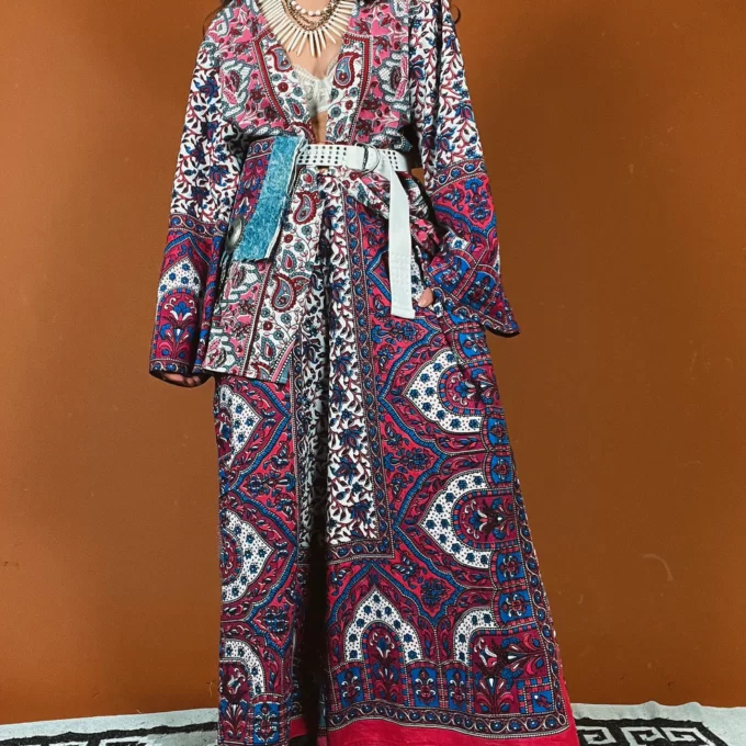 a woman in a long dress standing on a rug.