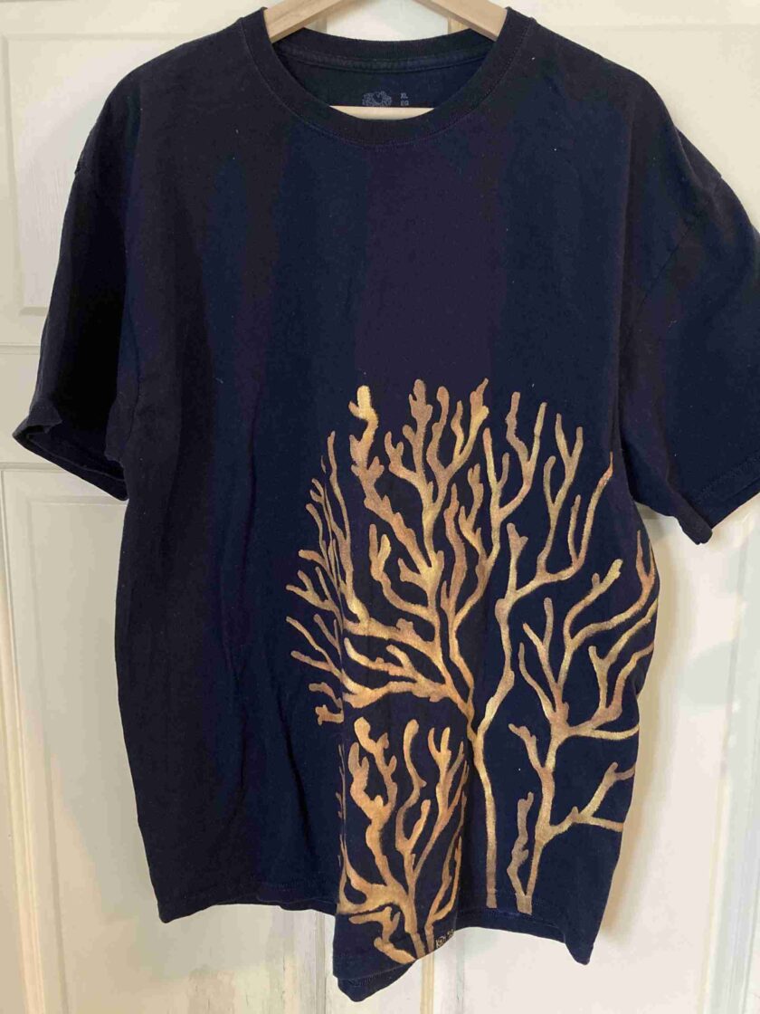 a black t - shirt with a gold tree on it.