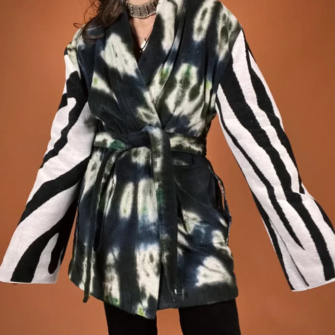 a woman in a black and white tie dye coat.