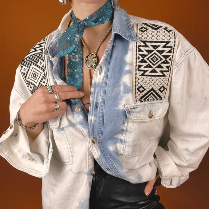 a woman wearing a tie and a denim shirt.