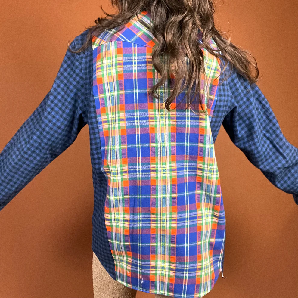 a young girl wearing a blue and orange plaid shirt.