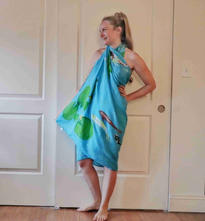a woman in a blue towel standing in front of a door.