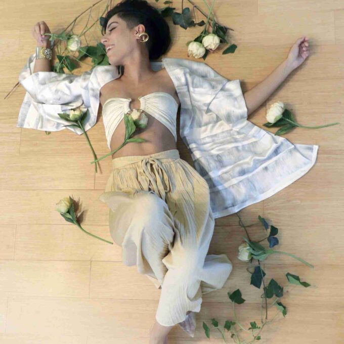 a woman laying on the floor with flowers around her.