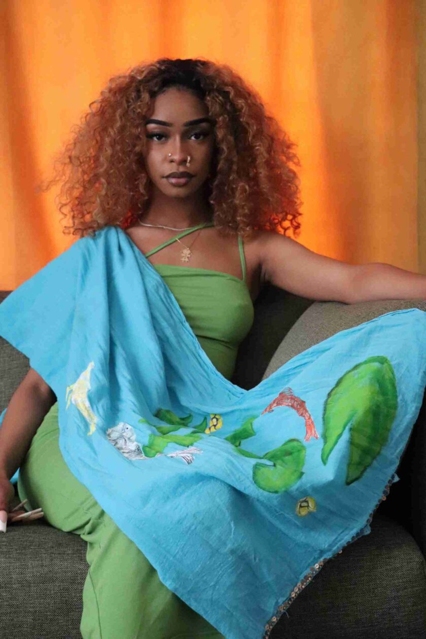 a woman sitting on a couch holding a blue scarf.