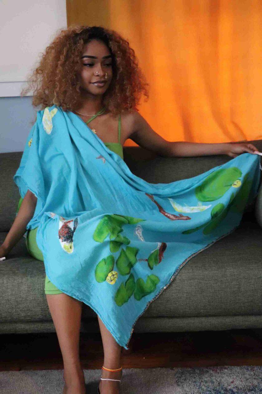 a woman sitting on a couch wearing a blue dress.